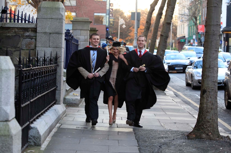 Three happy business graduates on road side