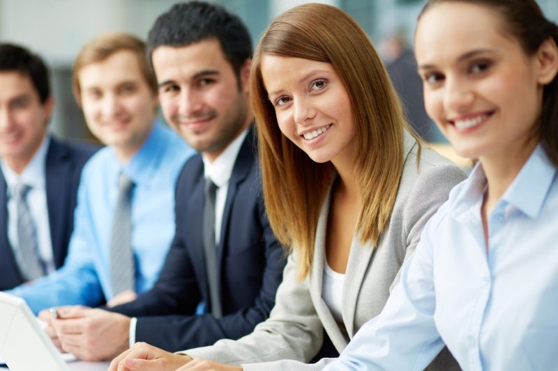 Closeup of five business school sudents smiling in front of camera